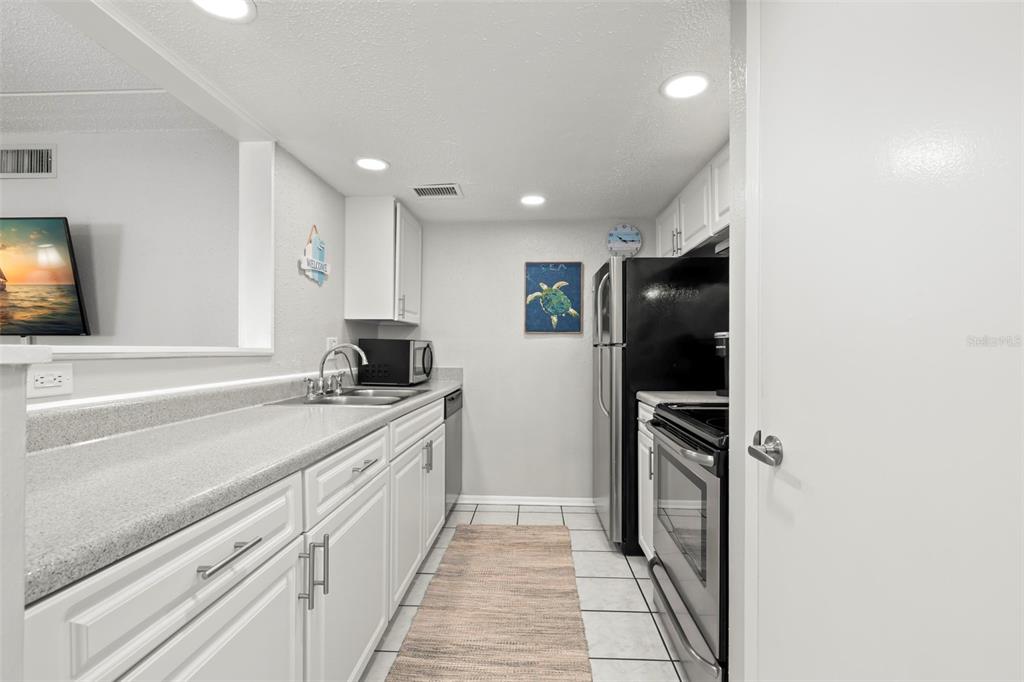 8911 Blind Pass Road, Unit 214 St. Pete Beach, FL 33706 - Photo 9 of 35 a kitchen with a sink and a refrigerator