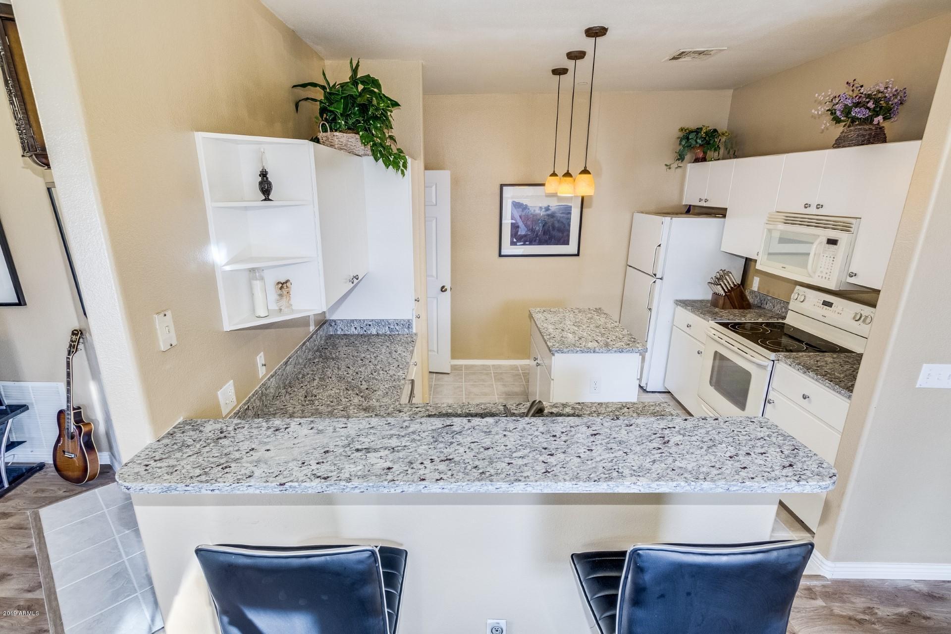 9550 East Thunderbird Road, Unit 252 Scottsdale, AZ 85260 - Photo 6 of 21 a kitchen with kitchen island a counter top space a sink a stove and refrigerator