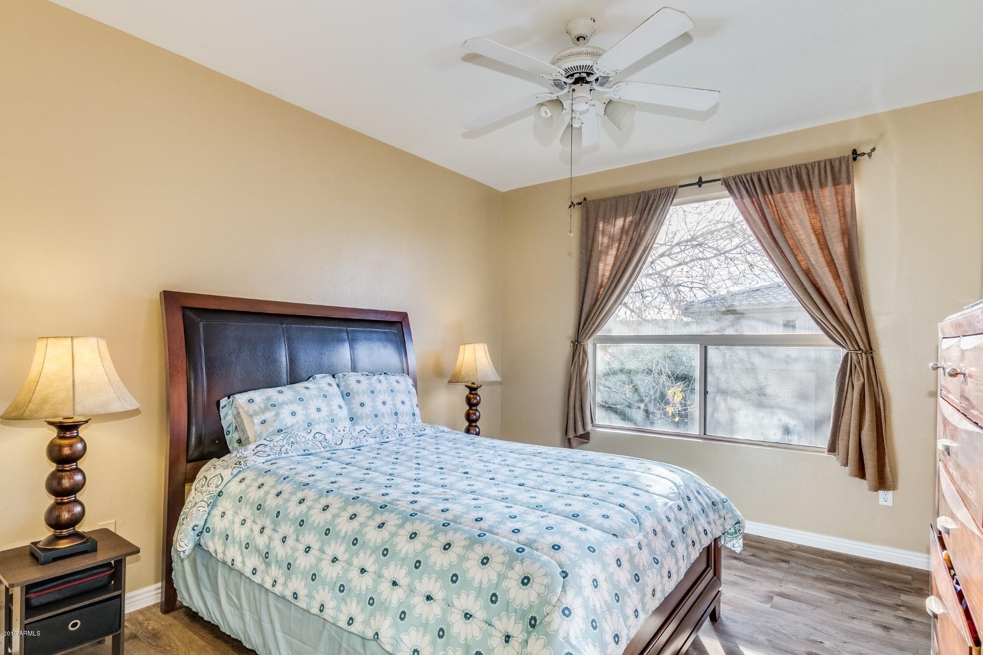 9550 East Thunderbird Road, Unit 252 Scottsdale, AZ 85260 - Photo 10 of 21 a bedroom with a large bed and a chandelier