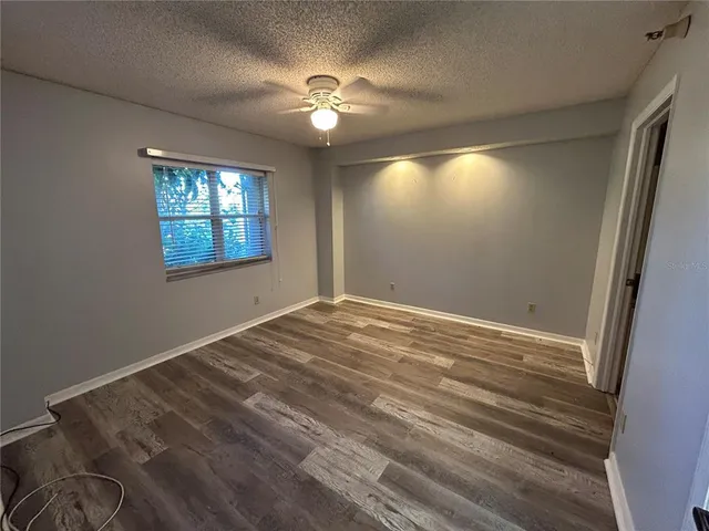 a view of empty room with window and chandelier fan