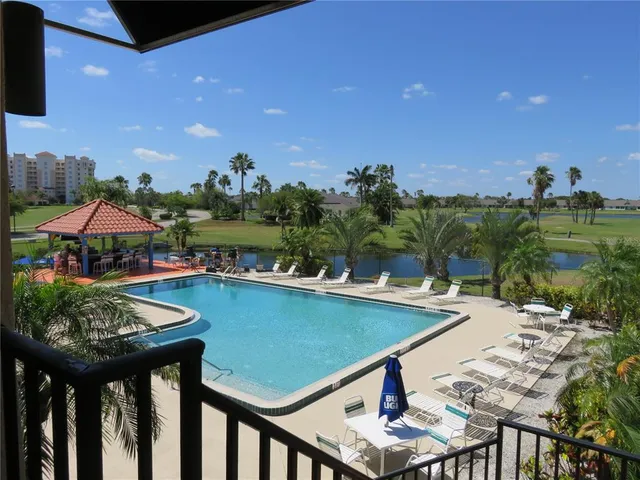 a view of a swimming pool with outdoor seating and plants