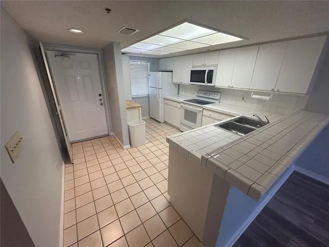 a kitchen with a sink appliances and cabinets