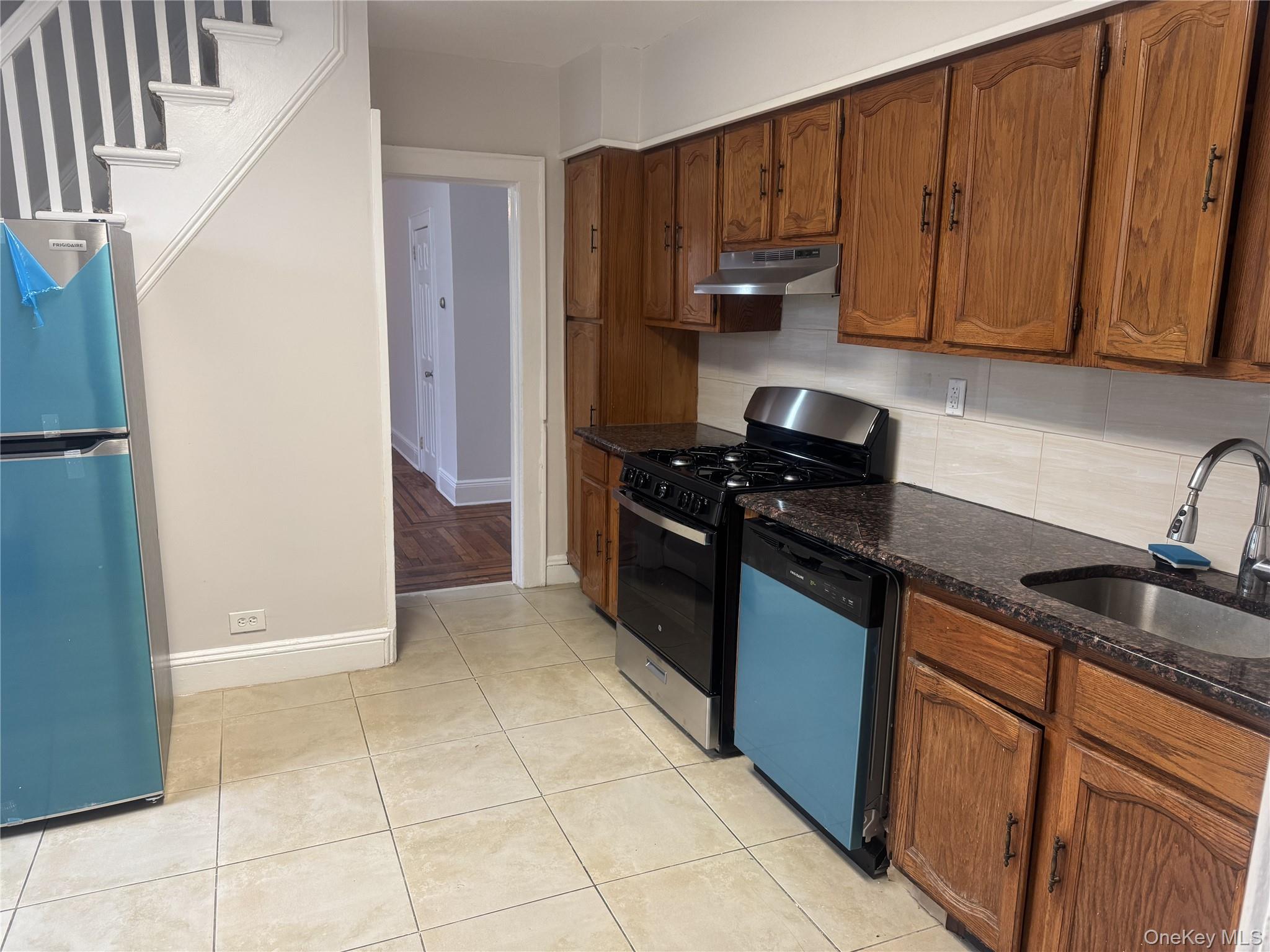 267 Schenck Avenue, Unit # RIGHT Great Neck, NY 11021 - Photo 7 of 8 Kitchen with sink, stainless steel appliances, dark stone counters, decorative backsplash, and light tile patterned flooring