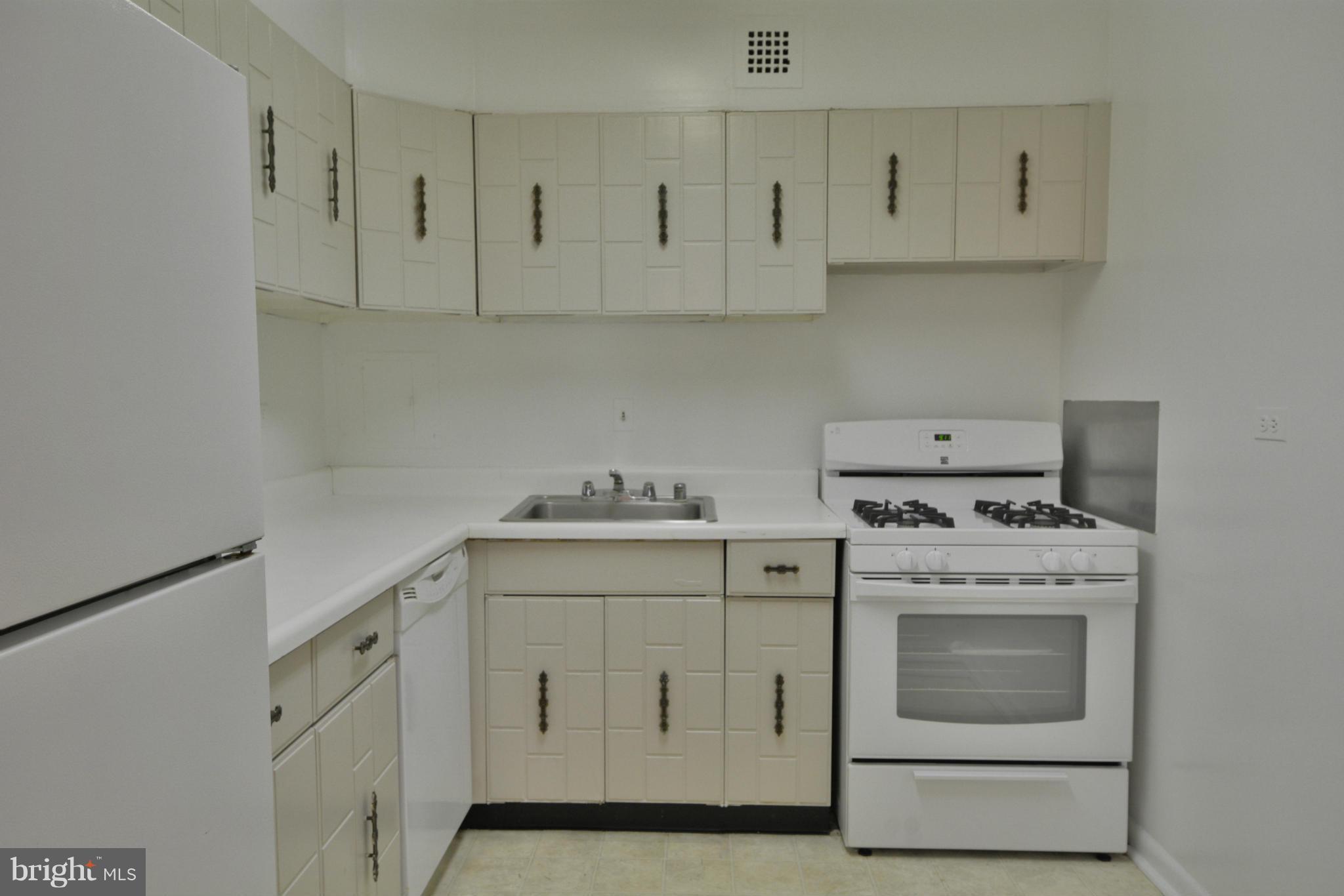 700 7th Street Southwest, Unit 630 Washington, DC 20024 - Photo 10 of 28 a kitchen with white cabinets and white appliances