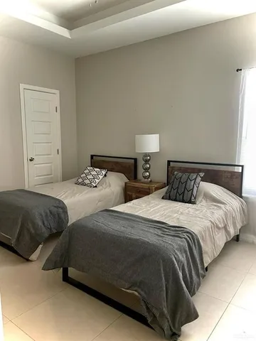 a bedroom with two beds and a lamp