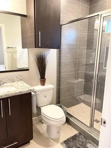 a bathroom with a granite countertop sink toilet and shower