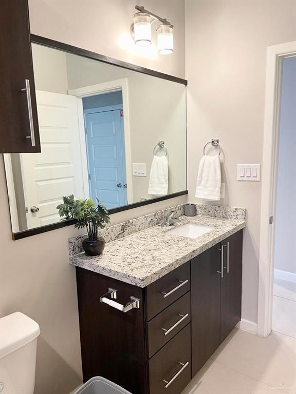 3007 Javalina Avenue, Unit 4 Edinburg, TX 78542 - Photo 10 of 16 a bathroom with a granite countertop sink and a mirror