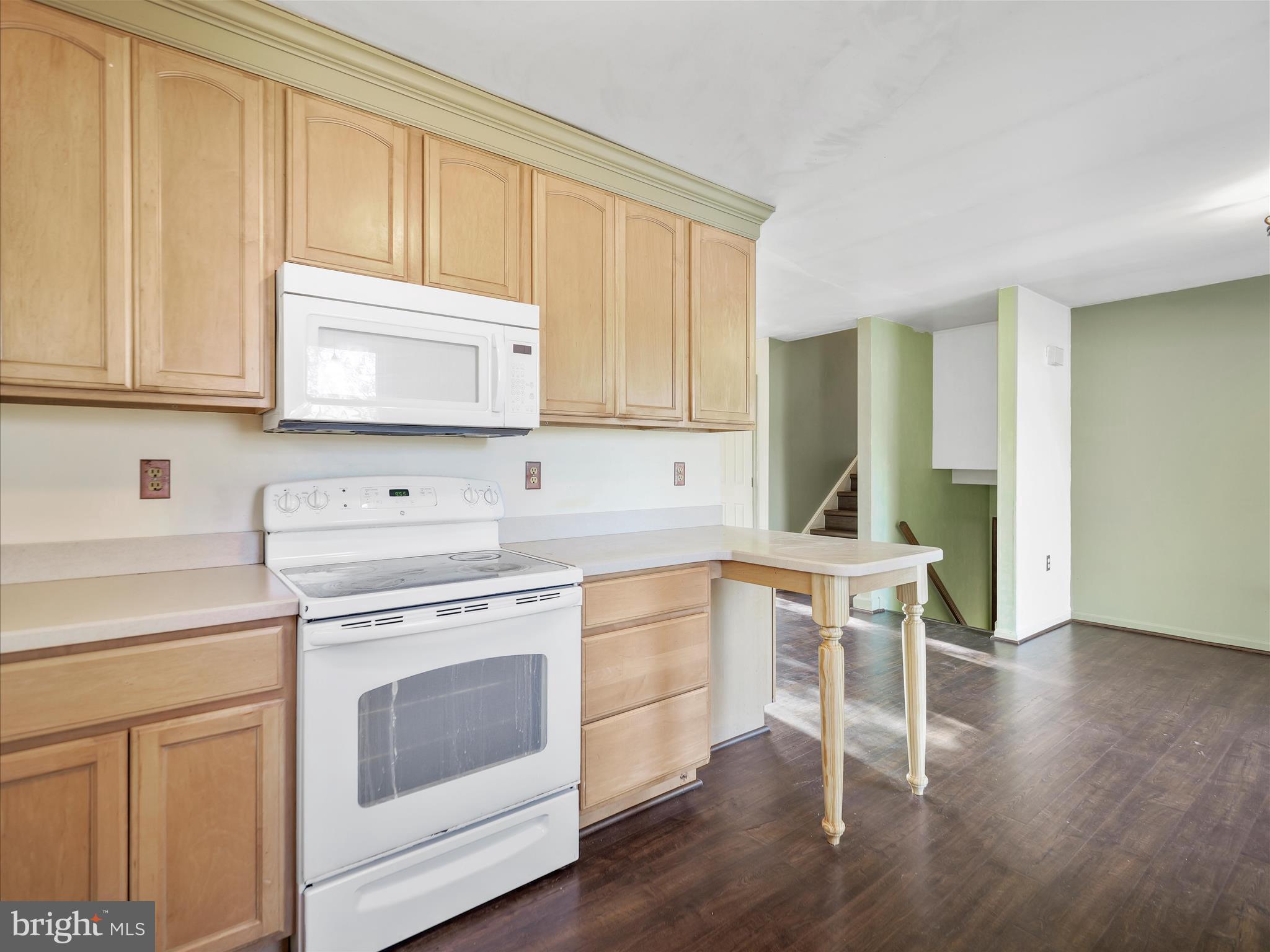 104 Rebecca's Court Smithsburg, MD 21783 - Photo 11 of 34 a kitchen with a stove a sink and white cabinets with wooden floor