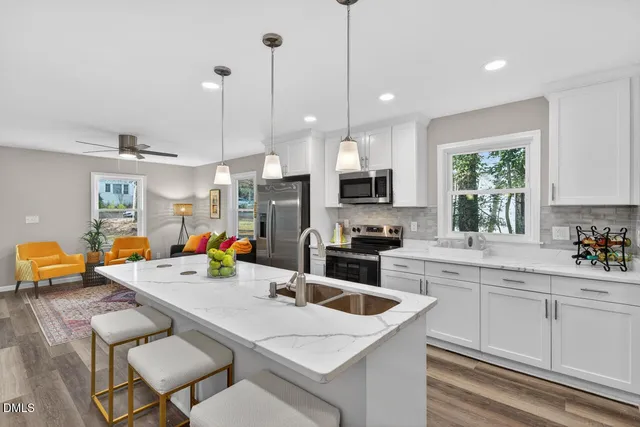 a kitchen with stainless steel appliances kitchen island granite countertop a sink a stove and cabinets