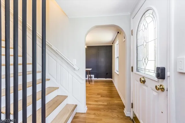a view of a hallway with wooden floor and staircase