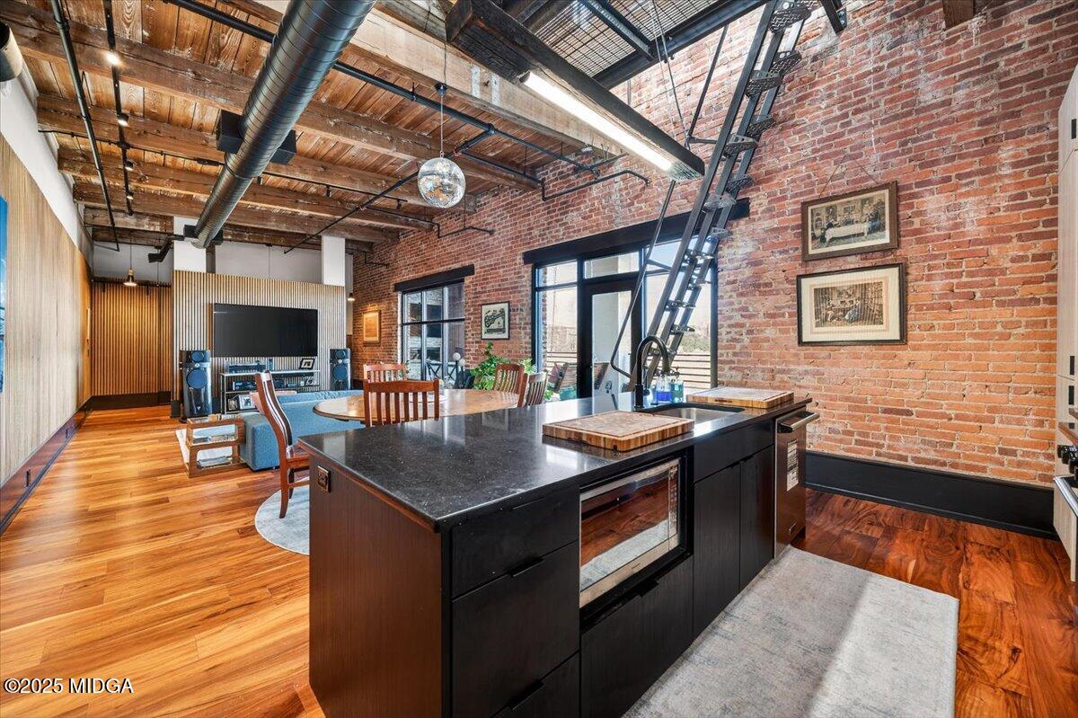 a kitchen with stainless steel appliances granite countertop a sink a stove and a wooden floors