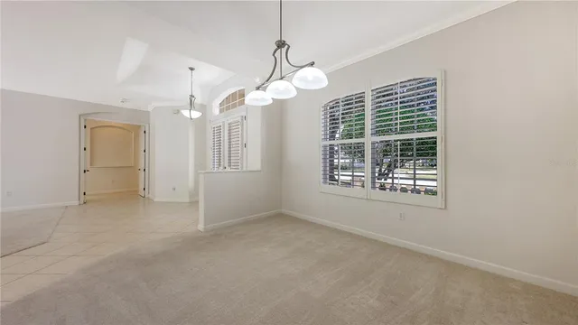 en empty room with windows and chandelier