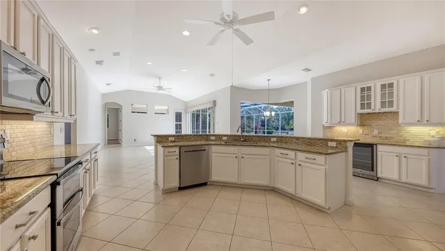 a large kitchen with granite countertop a stove a sink dishwasher and a refrigerator