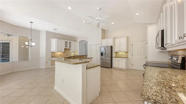 a kitchen with stainless steel appliances granite countertop a refrigerator and a stove top oven