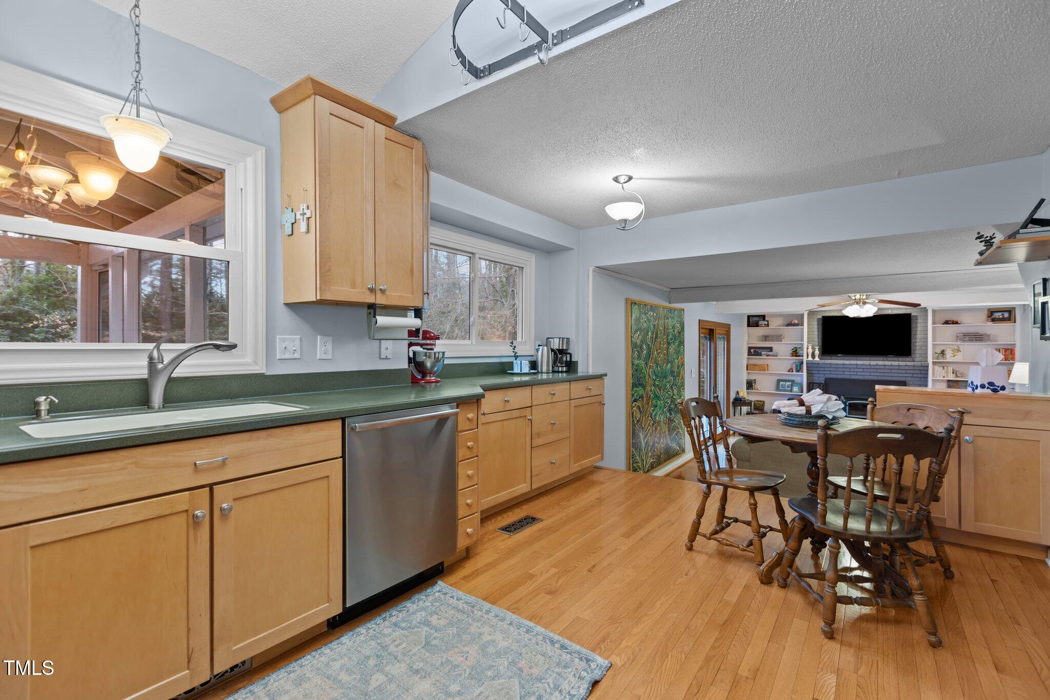 7612 Harps Mill Road Raleigh, NC 27615 - Photo 12 of 49 a kitchen with stainless steel appliances granite countertop a table chairs sink and cabinets