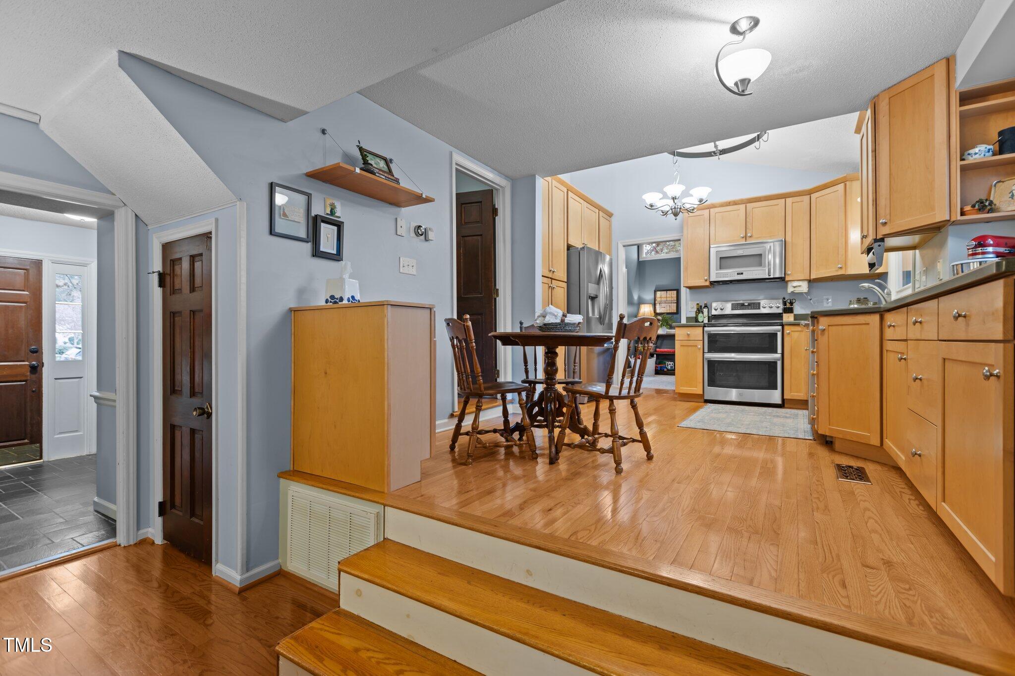 7612 Harps Mill Road Raleigh, NC 27615 - Photo 13 of 49 a view of a kitchen with dining room and wooden floor
