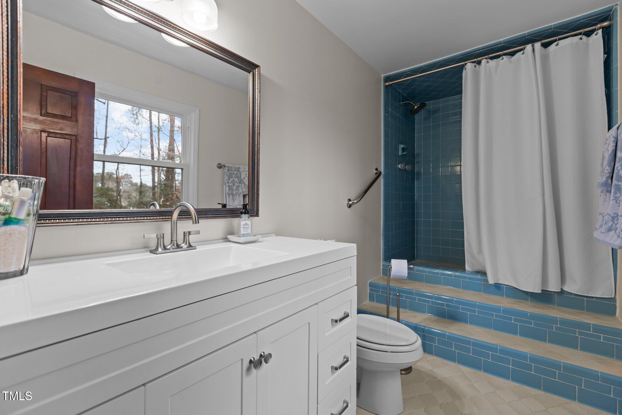 7612 Harps Mill Road Raleigh, NC 27615 - Photo 25 of 49 a bathroom with a sink a toilet and shower