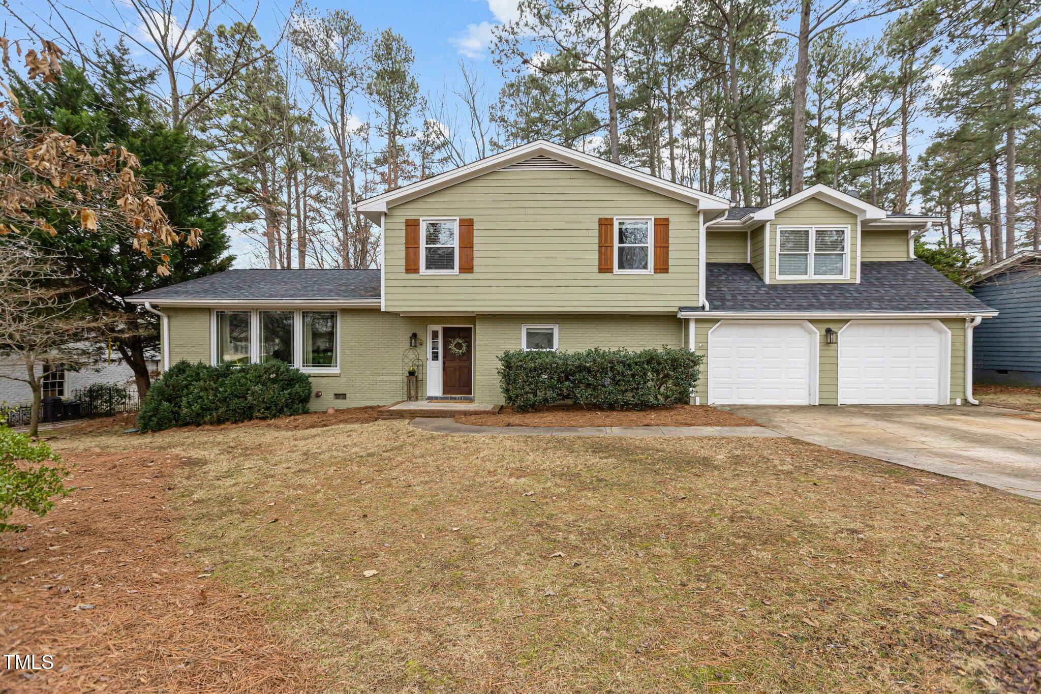 7612 Harps Mill Road Raleigh, NC 27615 - Photo 2 of 49 a front view of a house with a garage and a yard