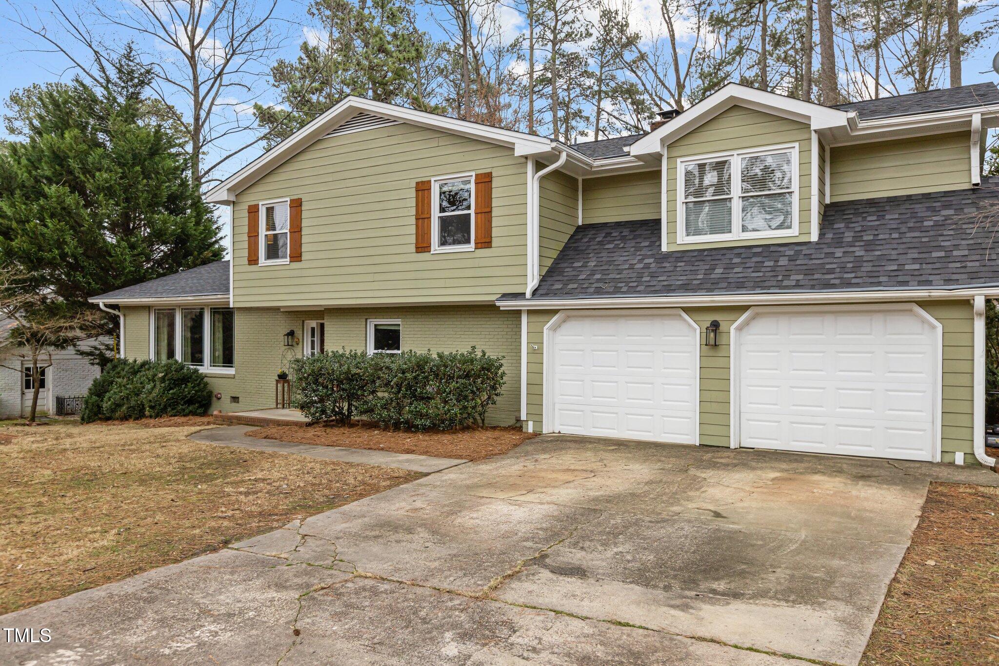 7612 Harps Mill Road Raleigh, NC 27615 - Photo 3 of 49 a front view of a house with a yard and garage