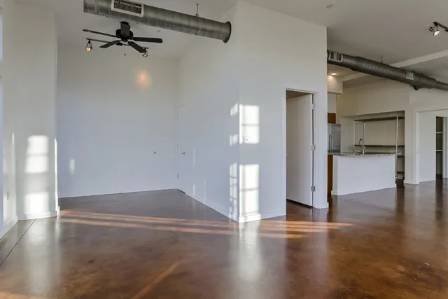 a view of empty room with wooden floor and window