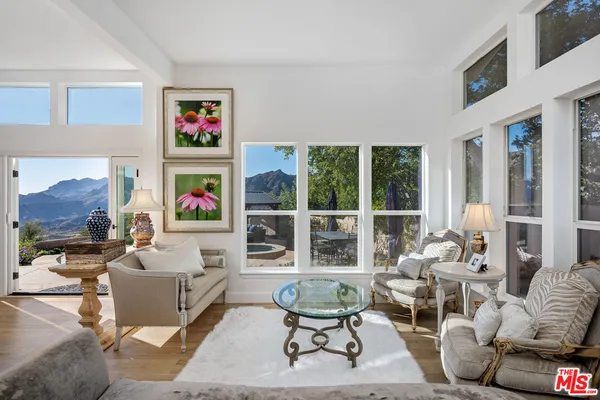 a living room with furniture and a floor to ceiling window