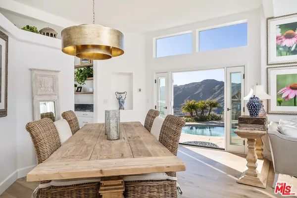 a view of a dining room with furniture a chandelier and wooden floor