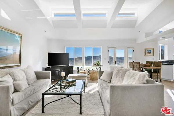 a living room with furniture a rug and a flat screen tv