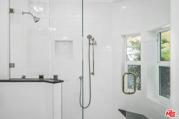 a bathroom with a shower a mirror and a shower