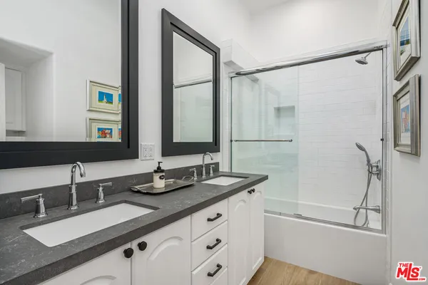 a bathroom with a double vanity sink and a mirror
