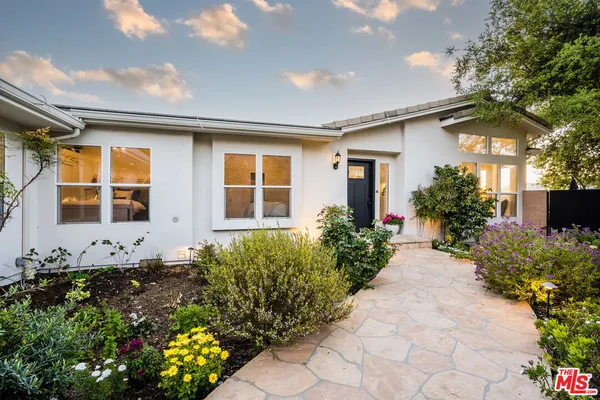 a front view of a house with a yard and flowers