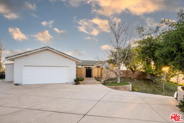 a view of a house with a yard and large tree