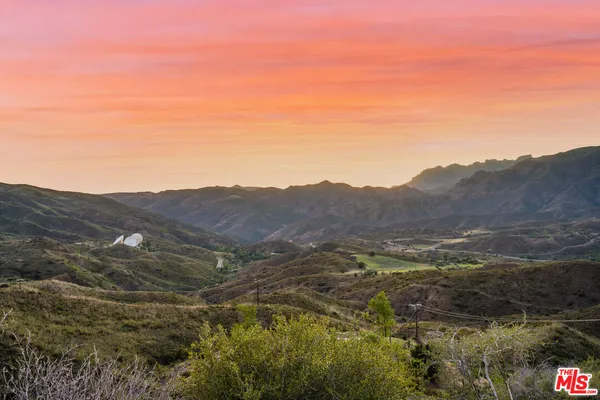 a view of a mountain range with lush green forest