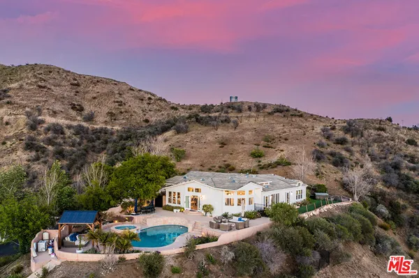 a view of a house with a yard and sitting area