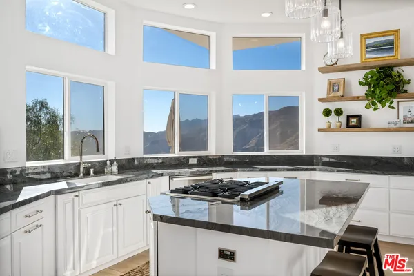 a kitchen with stainless steel appliances granite countertop a sink stove and cabinets