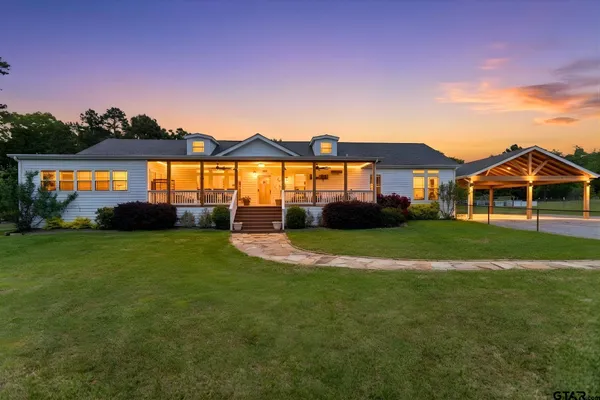 a front view of a house with a garden and yard