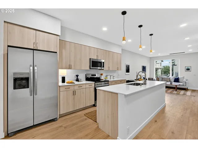 a kitchen with stainless steel appliances a refrigerator sink and microwave