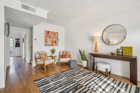 a living room with furniture and a wooden floor