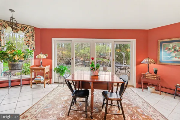 a dining room with furniture and a floor to ceiling window