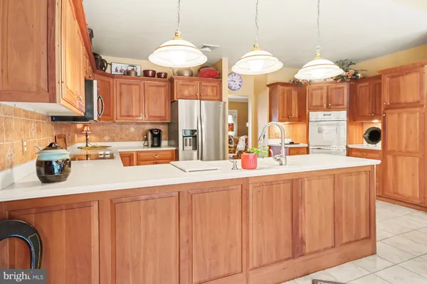 a kitchen with stainless steel appliances a table and a chandelier