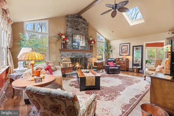 a living room with furniture fireplace and a large window