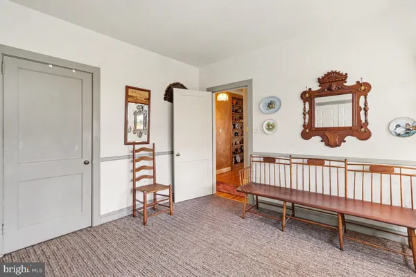 a view of an empty room with window and hardwood floor