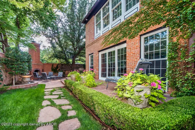 a view of a patio with table and chairs potted plants and a large tree