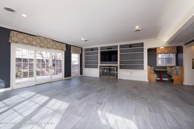 a view of empty room with wooden floor and windows