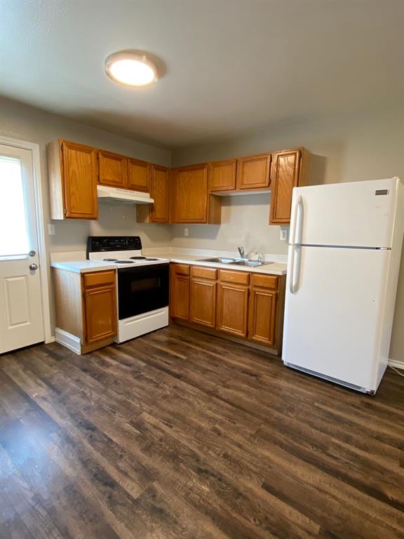 705 Miracle Lane, Unit A Cleburne, TX 76033 - Photo 5 of 7 a kitchen with stainless steel appliances granite countertop a refrigerator a stove a sink dishwasher and wooden floor