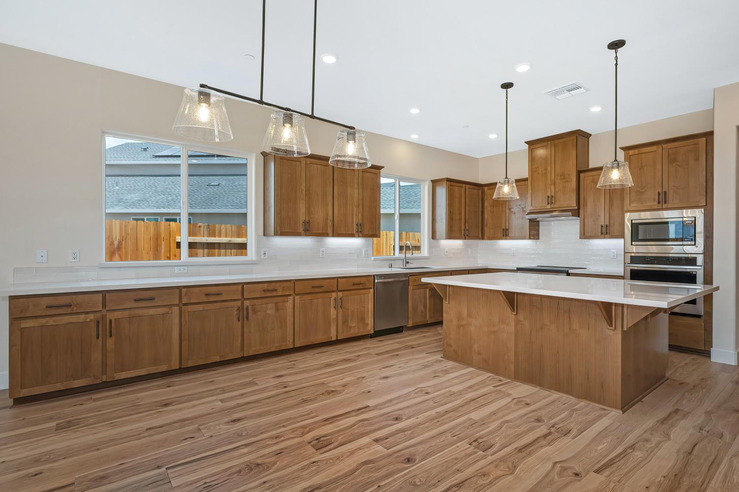 3922 Buxus Road Rocklin, CA 95765 - Photo 3 of 11 a large kitchen with stainless steel appliances kitchen island granite countertop a sink counter space and wooden floor
