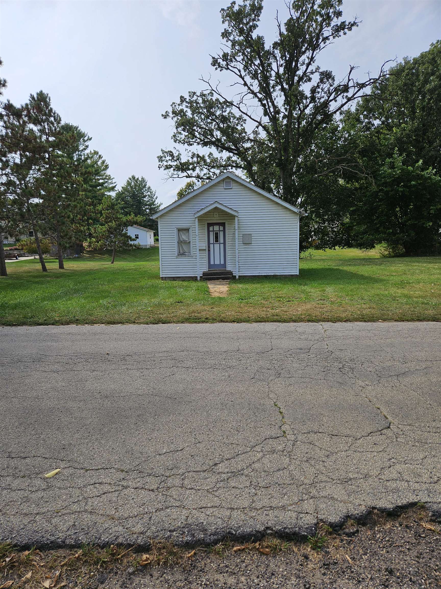 a view of a house with a yard and large tree