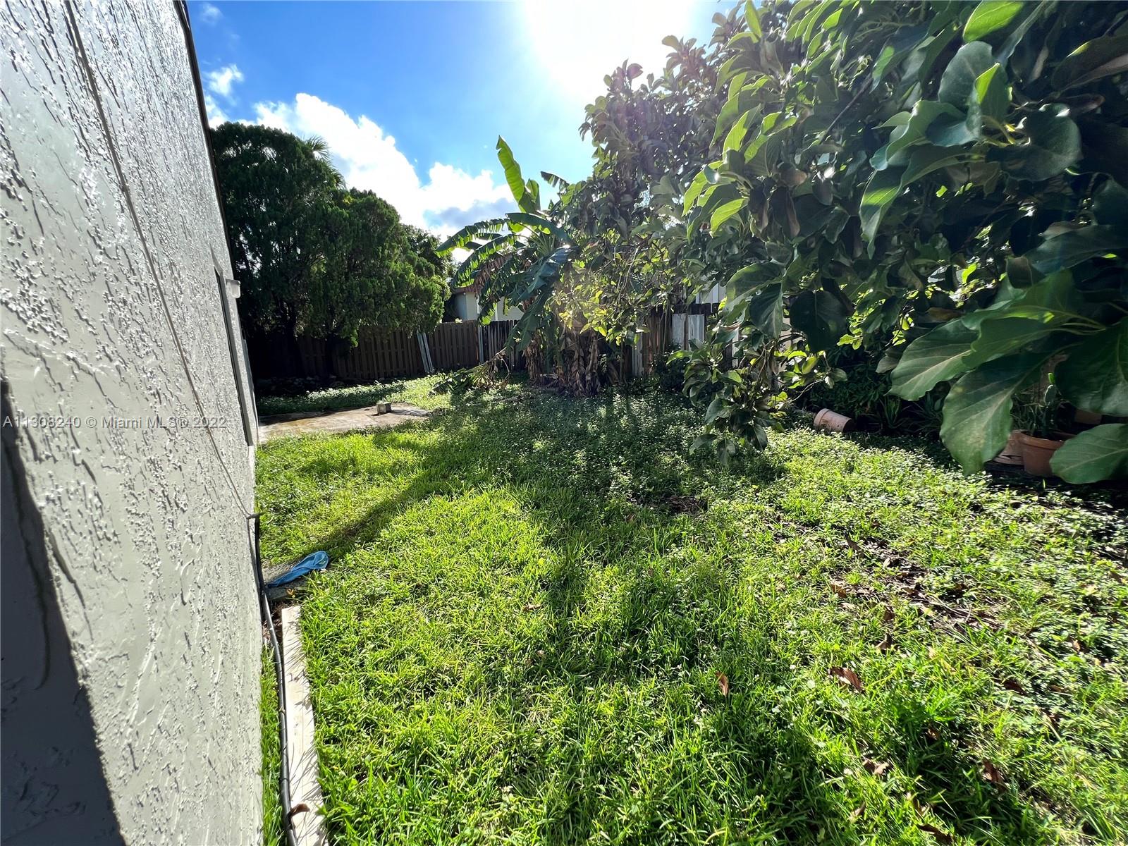 9630 Southwest 152nd Avenue, Unit 34 Miami, FL 33196 - Photo 13 of 13 a backyard of a house with lots of green space
