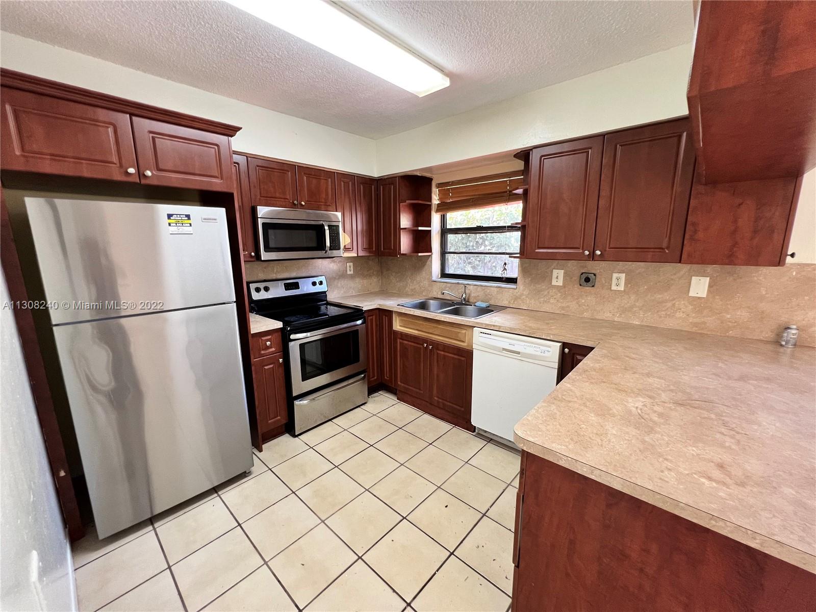 9630 Southwest 152nd Avenue, Unit 34 Miami, FL 33196 - Photo 4 of 13 a kitchen with stainless steel appliances granite countertop a refrigerator stove a sink dishwasher and a refrigerator