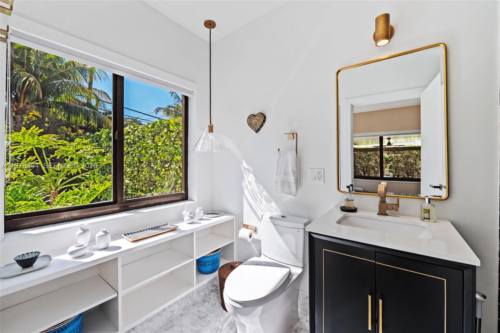 740 Northeast 76th Street Miami, FL 33138 - Photo 17 of 43 a bathroom with a sink a toilet and a mirror