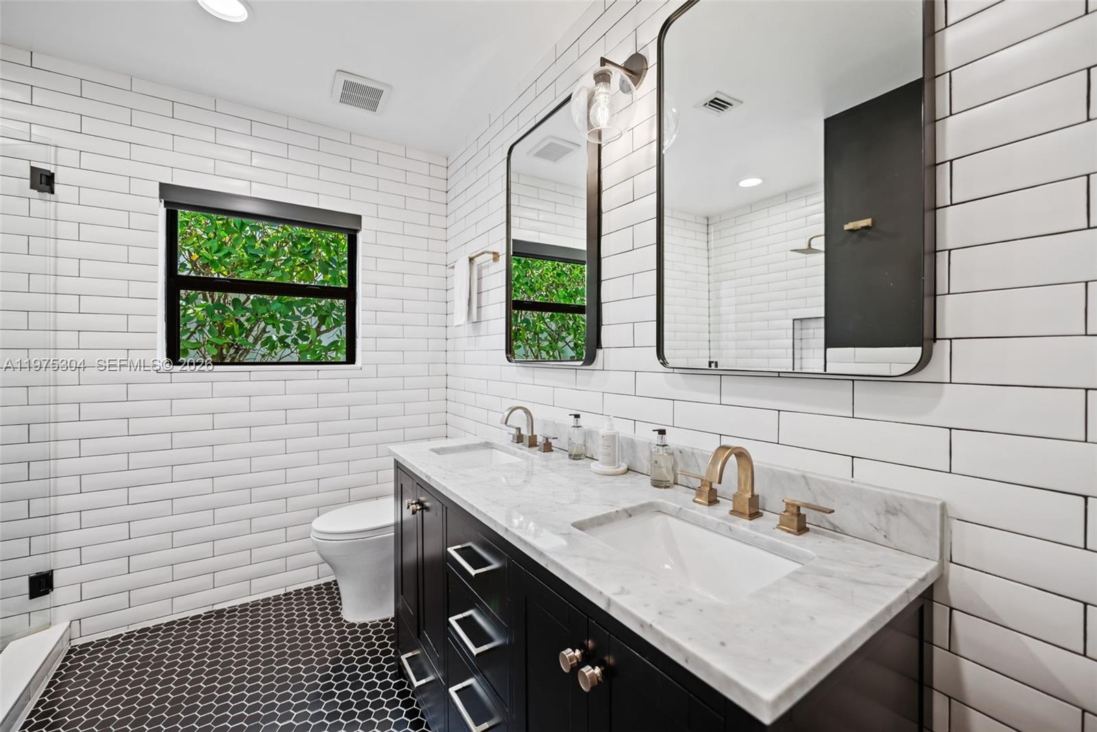 740 Northeast 76th Street Miami, FL 33138 - Photo 23 of 43 a bathroom with a sink a toilet and mirror